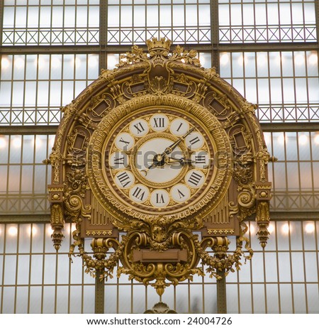 Extremely large, golden colored clock inside Musee d\'Orsay Museum in Paris, France, which contains contemporary artwork