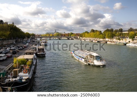 Seine River on a beautiful Fall day with boats and trees along the banks of the river in Paris, France