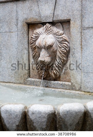 Ancient stone lion head water fountain on an old street in Macau, China