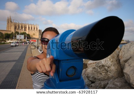 woman looks through telescope on city Palma de Mallorca