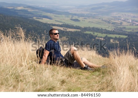 sportive man on the mountain trek, man sit and rest