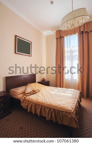 Interior of a hotel room for two, just a bed near window.