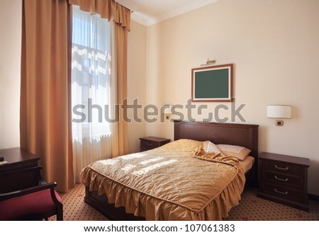 Interior of a hotel room for two, just a bed near window.