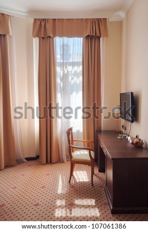 One part of a hotel apartment, vintage style, just a chair near the window.