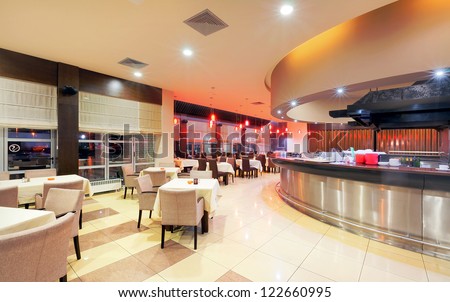 Modern restaurant interior, part of a hotel, night scene.