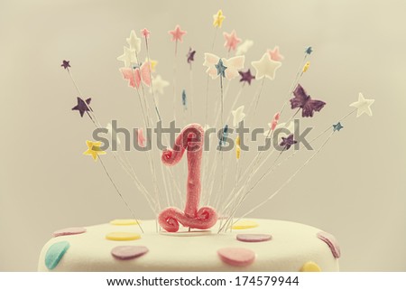 Cake for first birthday, number one made of sugar on top with stars around it.