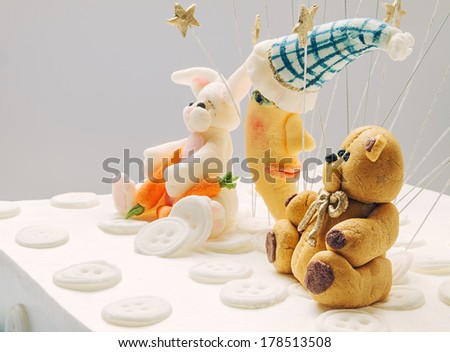 Birthday cake decoration, bear, moon and rabbit made of sugar, put on top of cake.
