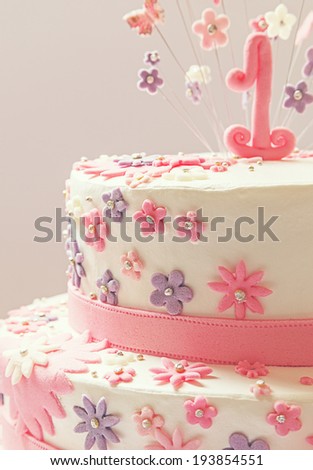 Details of a birthday cake, number one on top and stars around it, made of sugar.