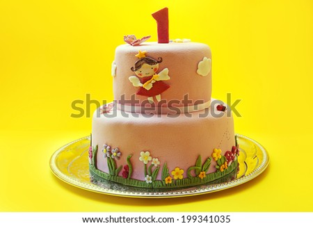 Decoration of a birthday cake with number one made of sugar on top.
