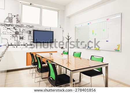 Office interior in white with printed wallpapers presenting part of a machine structure.
