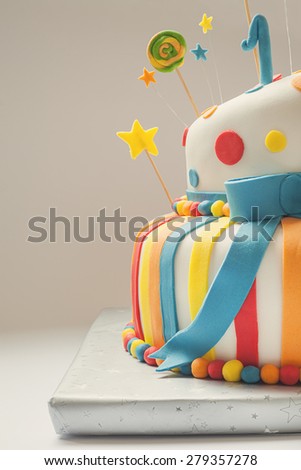 Funny birthday cake with number one on top, sweet colorful decoration.