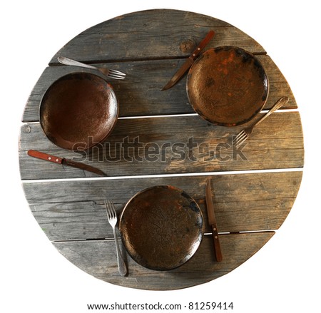 Prepared an old table for lunch, three plates, forks and knifes. Isolated on white background, viewed from above.