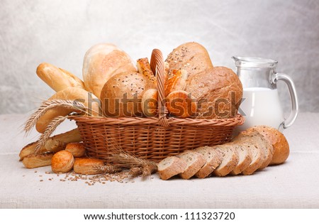 Fresh bread and pastry with milk on jug
