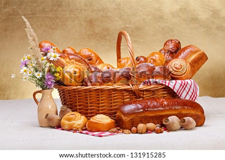 Sweet bakery products in basket, wild flower decoration, rustic background
