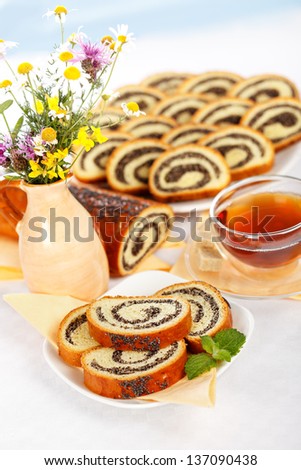 Poppy seed roll slices breakfast along sweet cakes, coffee and wild flowers