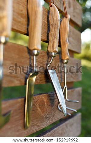Garden tools on board fence in garden