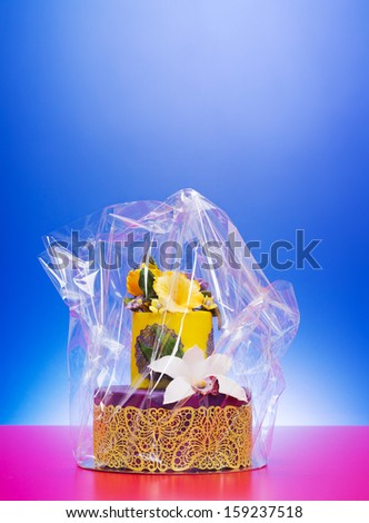Colorful purple-yellow cake decorated with edible candy flowers and lace in cellophane wrap