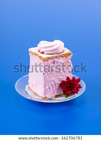Pink fruit mousse cake on blue background