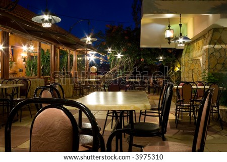 Tables and chairs in a greek restaurant at night