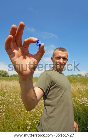 Guy holding small earth globe - the world in his hands ( focus on the ball )