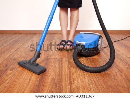 Woman cleaning the floor with vacuum cleaner