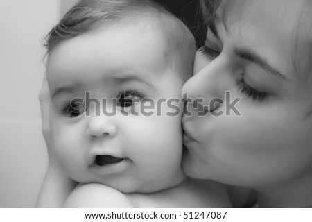 black and white kissing photography. stock photo : Mother giving a