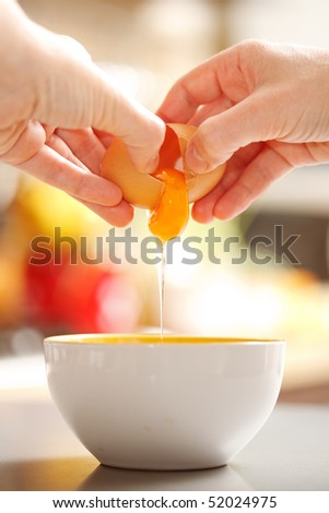 Preparing food: hands cracking up a raw egg