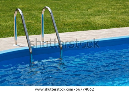 Blue pool with fresh and clean water and green grass
