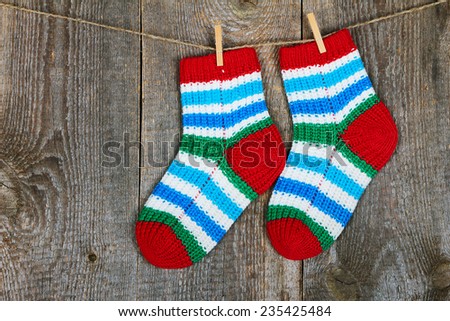 Colorful socks hanging on the clothesline on old wooden background