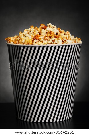 Popcorn in a container on black background