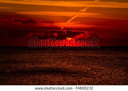 mystery sunset over  Red sea. Sun, colorful sky and clouds over dark sea