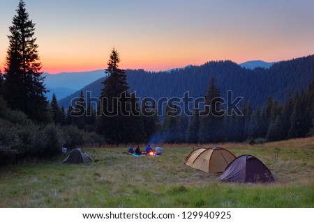 Evening by the fire in the mountains. Camping in tents in the mountains.