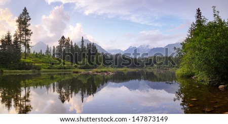 View from the mountain lake and pine forest. Slovakia, small lake Strbske Pleso