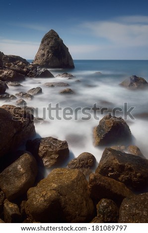 Sea landscape with rocks near the shore waves and foam. Moonlit night and stormy sea. Crimea, Ukraine, Europe