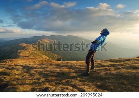 Man balances. Strong wind in the mountains. Autumn Landscape
