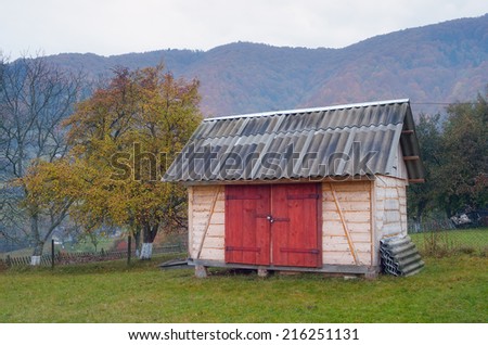 Country yard with wooden shed. Autumn in mountain village