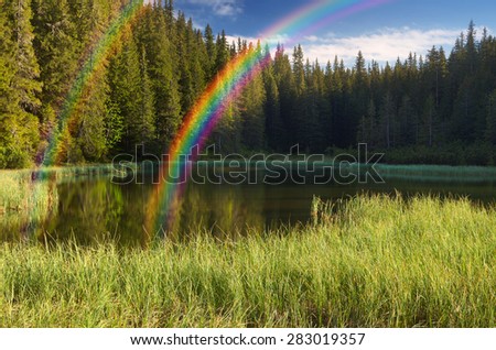 Morning landscape with forest lake and rainbow