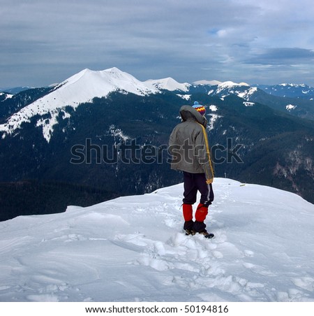The man costs at top of mountain in the winter