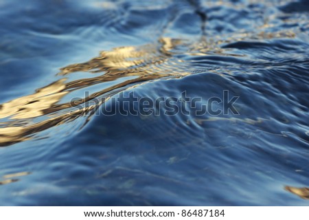 Water surface in the river and reflection in it of the coming sun