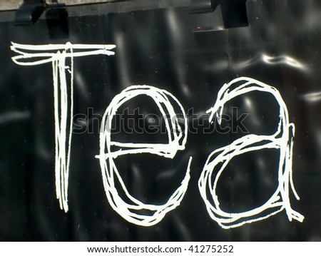 the word tea written on a black metal plate out of a coffee shop in London