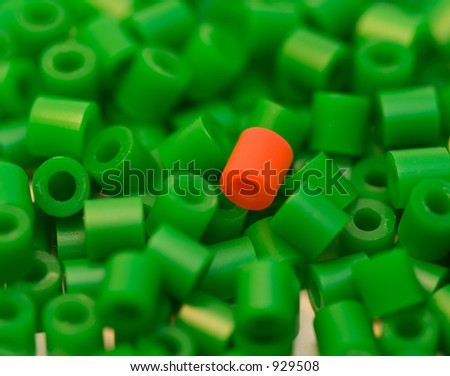 red plastic bead among many green beads