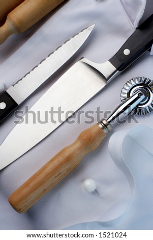 Chef\'s uniform, folded and arranged with tools of trade. Part of a series.