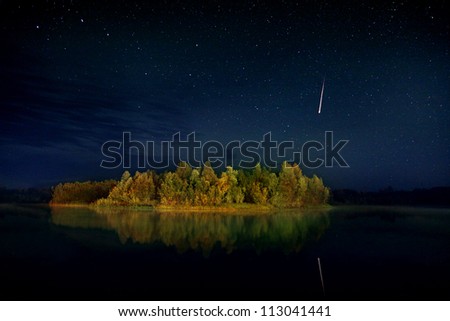 Night landscape, wooded island in the lake in the night sky, the constellation of the Great Bear and the shooting star