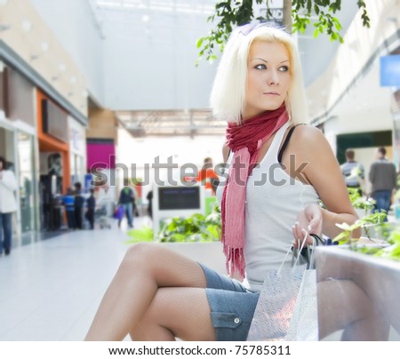 Portrait of woman at the mall with bags, which sat down to rest copyspase
