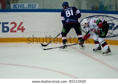 NOVOSIBIRSK - SEPTEMBER 26:  Ice hockey, the game between Siberia and AK Bars forward Knyazev (Ak Bars) interferes with a club for defender Puyats (Siberia) on September 26, 2011, Novosibirsk Russia