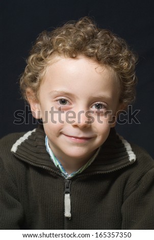 portrait of a boy of five years, curly blond hair, green eyes, smiling