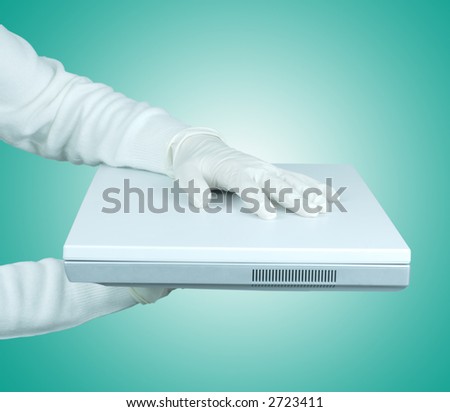 Hand in gloves handing over a white laptop