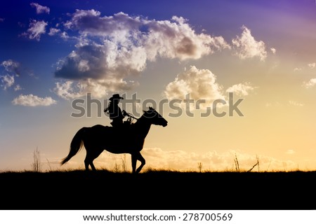 Cowgirl on horse taking an afternoon ride through the pasture at sunset