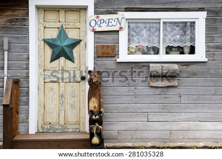 Rustic country store with open sign and star decor on the door.