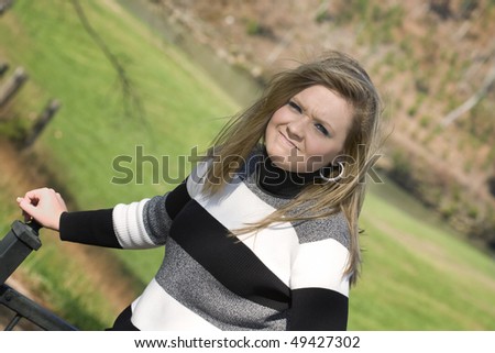 Beautiful young woman frustrated because the wind wont stop blowing her hair